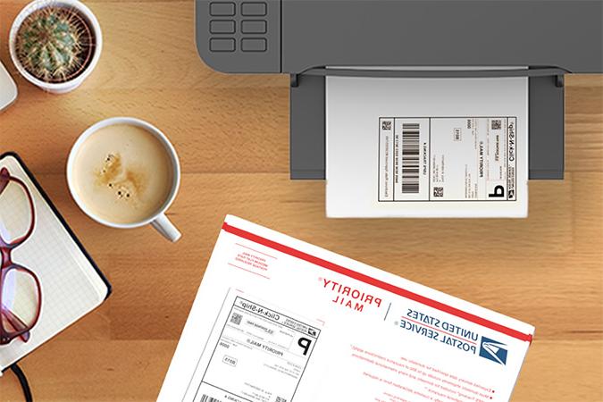 CNS标签在优先邮件信封旁边的打印机托盘中等待.